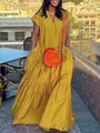 Model wearing a vibrant yellow short-sleeve V-neck maxi dress in a sunny outdoor setting - S / Bottoms / Yellow
