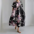 Dettaglio dell'abito lungo nero ampio con eleganti stampe floreali e motivi di gru - Gru