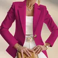 Detailansicht eines fuchsiafarbenen Blazers mit weißer Hose und goldenem V-Logo-Gürtel. - Fuchsia