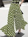 Detailed view of women's green high-waisted wide-leg pants featuring white polka dots - S / Bottoms / Green