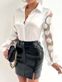 Detailed view of fashion white blouse featuring sheer mesh sleeves with 3D appliques - S / Tops / White