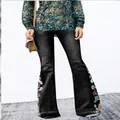 Détail rapproché d'un jean évasé pour femme avec broderie florale colorée sur le côté. - 3XL / Bas / Noir (6122)