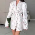Blazer blanco con estampado floral rosa, cinturón ajustable y cuello de solapa - Flor Blanca