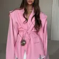 Primer plano de un blazer rosa oversize con cintura anudada y mangas únicas - S / Tops / Rosa