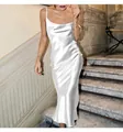 Elegant white satin spaghetti strap fishtail midi dress on model at stone stairs - S / Bottoms / White