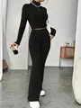 Detailed view of a black ribbed knit two-piece set with a crop top and flared pants. - S / Top And Bottom / Black
