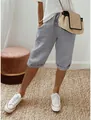 Primo piano del modello che indossa pantaloni capri casual in cotone e lino grigi con coulisse - Taglia S / Grigio chiaro