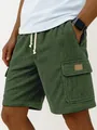 Macro view of green corduroy cargo shorts featuring a side pocket and drawstring waist - S / Bottoms / Dark Green