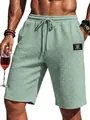 Detail of men's sage green waffle knit shorts with drawstring waist and logo patch - S / Bottoms / Light Green