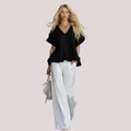 Élégante blouse femme noire à col en V et ourlet à volants pour un style de mode estivale. - S / Hauts / Noir