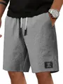 Dettaglio della trama a nido d'ape e della toppa decorativa sui pantaloncini da uomo - Taglia M / Pantaloni e gonne / Grigio