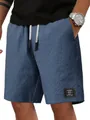 Nahaufnahme blauer Waffelstrick-Herrenshorts mit Textur, Kordelzug und klassischem Aufnäher - Marineblau