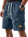 Gros plan d'un short pour hommes en maille gaufrée bleu marine avec écusson en cuir. - Bleu marine