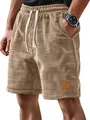 Detailed view of men's brown waffle knit shorts featuring drawstring and leather patch - S / Bottoms / Khaki