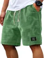 Macro view of the high-quality green waffle knit texture on men's casual summer shorts - M / Bottoms / Green