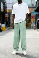 Full-length view of men's loose straight-leg corduroy pants in a pale mint green shade - S / Light Green
