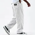 Detailed view of white corduroy trousers with vertical stripes and retro pocket patch. - S / Bottoms / White