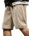 Close-up of textured jacquard pattern and woven label on beige casual shorts - S / Bottoms / Apricot
