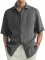 Close-up view of a grey washed cotton shirt showing its textured fabric and buttons. - M / Tops / Gray