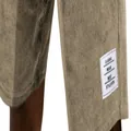 Macro close-up detail of white woven label on men's khaki corduroy shorts leg cuff - Khaki