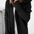 Close-up of black oversized hooded knitted cardigan featuring textured batwing sleeves - S / Tops / Black