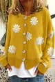 Nahaufnahme einer leuchtend gelben Strickjacke mit zarten weißen Gänseblümchen-Stickereien - Gelb