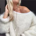 Detail eines weißen, flauschigen Oversize-Strickpullovers mit Mohair-Effekt an Model. - S / Oberteile / Weiß