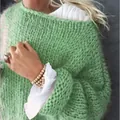 Detail eines grünen grob gestrickten Mohair-Pullovers mit weicher Textur für den Herbst - Obstgrün
