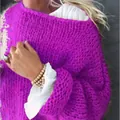 Detail eines übergroßen magentafarbenen Grobstrickpullovers mit Rüschenbündchen - Fuchsie