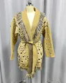 Detailweergave van een mosterdgeel gebreid vest met paisley-patroon en franjes. - S / Tops / camel