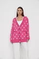 Stylish pink knitted cardigan featuring a white heart jacquard pattern on a model - S / Tops / Rose Red