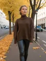 Vue détaillée d'une femme portant un pull à col roulé marron surdimensionné en plein air. - Café