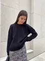 Close-up of women's loose crewneck black ribbed knit sweater on model outdoors - S / Tops / Black