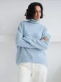 Detail of light blue thick knit sweater featuring a cozy loose turtleneck design. - Light Blue