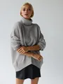 Detail view of a loose grey oversized turtleneck sweater with a cozy thick knit texture - Light Heather Grey