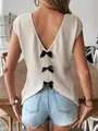 Close-up of white waffle knit top with deep V-back and three black ribbon bows. - S / Tops / Apricot