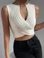 Close-up of a white knit top featuring cross-front design and gold chain necklace detail. - S / Tops / Apricot