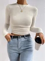 Close-up view of a slim-fit waffle knit long sleeve crop top in elegant cream color - S / Tops / Apricot
