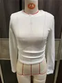 Detailweergave van een wit T-shirt met lange mouwen en getextureerde mesh stof - Wit
