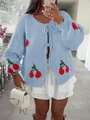 Detail of a blue knit cardigan with red cherry patterns and a tie-front closure style. - S / Tops / Sky Blue