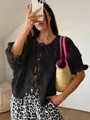 Black round neck knit cardigan featuring three front bow-tie closures and 3/4 sleeves. - S / Tops / Black
