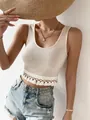 Detailed macro view showing the intricate knitted texture and tassel hem of this cream crop top - S / Tops / Apricot
