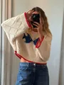 Detail of vintage cream knit sweater featuring blue bird jacquard and red contrast trim. - S / Tops / Apricot