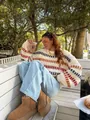Cozy oversized chunky knit sweater with colorful stripes in an outdoor cafe setting - S / Tops / Apricot