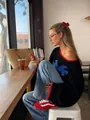 Retro oversized black jacquard knit sweater with red contrast trim in cafe setting - S / Tops / Black