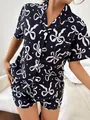 Nahaufnahme des stilvollen dunkelblauen Damenpyjamas mit weißem Schleifen-Stern-Muster - S / Oberteil Und Unterteil / Schwarz