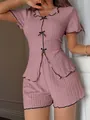 Detailed macro view of the mauve ribbed knit pajama set featuring delicate black bow accents - S / Top And Bottom / Pink