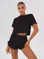 Detail view of women's black 100% cotton pajama set featuring red heart prints - S / Top And Bottom / Black