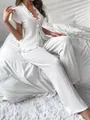 Dettaglio di un set pigiama bianco in maglia con cardigan con lacci e volant da donna - Taglia L / Top e Pantaloni / Bianco