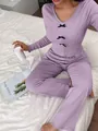 Detail of lavender pajama set with decorative black bows and ruffled edges - S / Top And Bottom / Purple